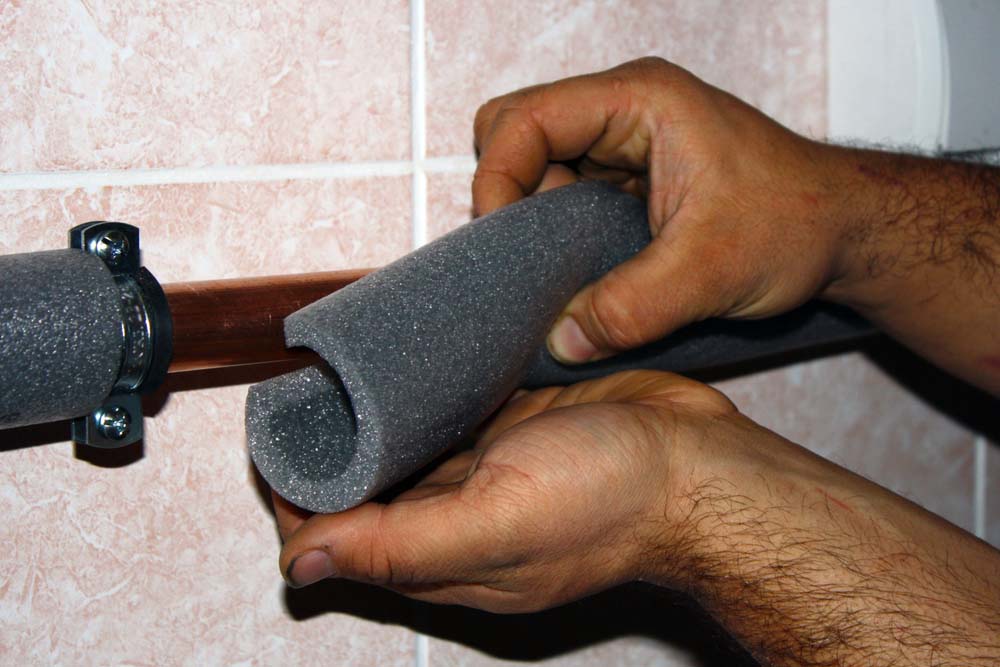 Straight Shooter technicians wrapping water lines with insulation