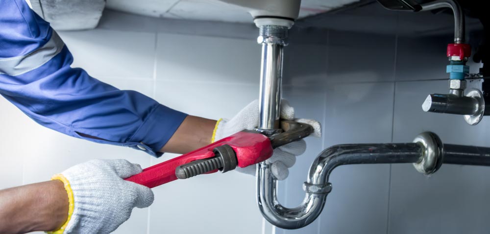 pipes being tightened with a monkey wrench