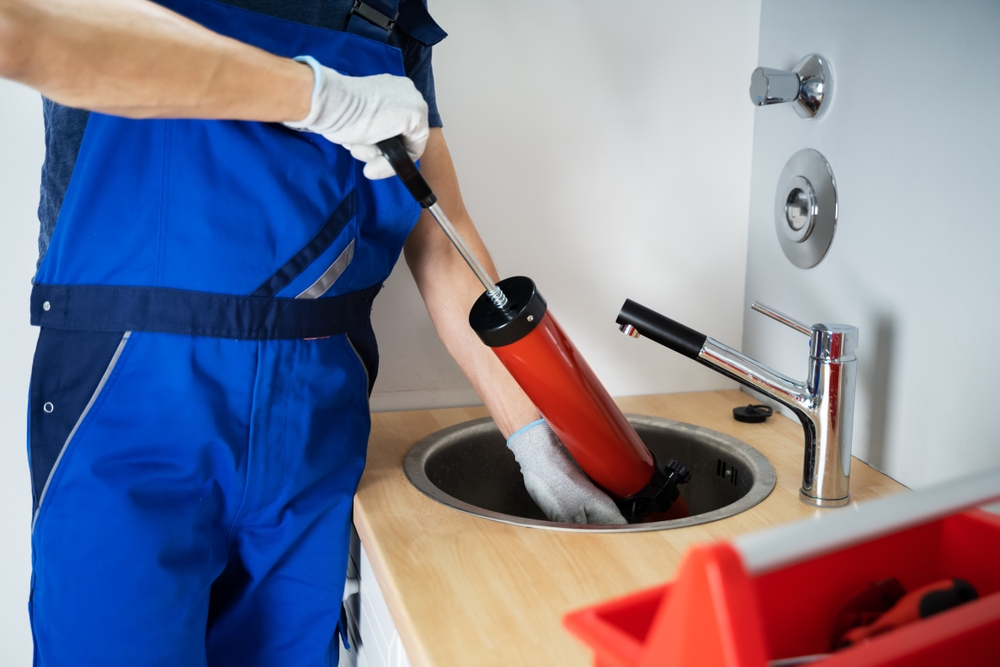 plumber with drain cleaning and camera inspection equipment